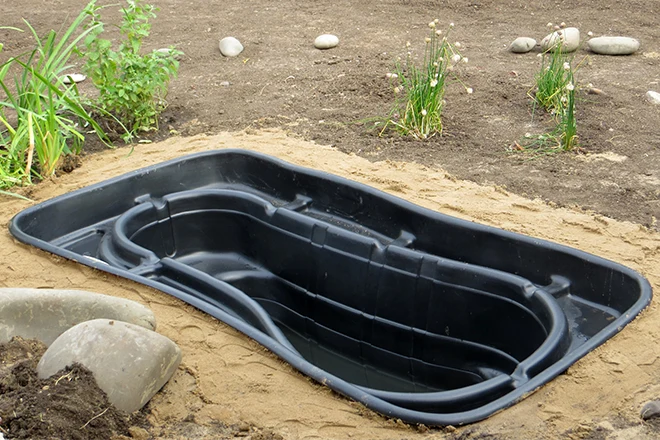 Preformed plastic pond insert in ground